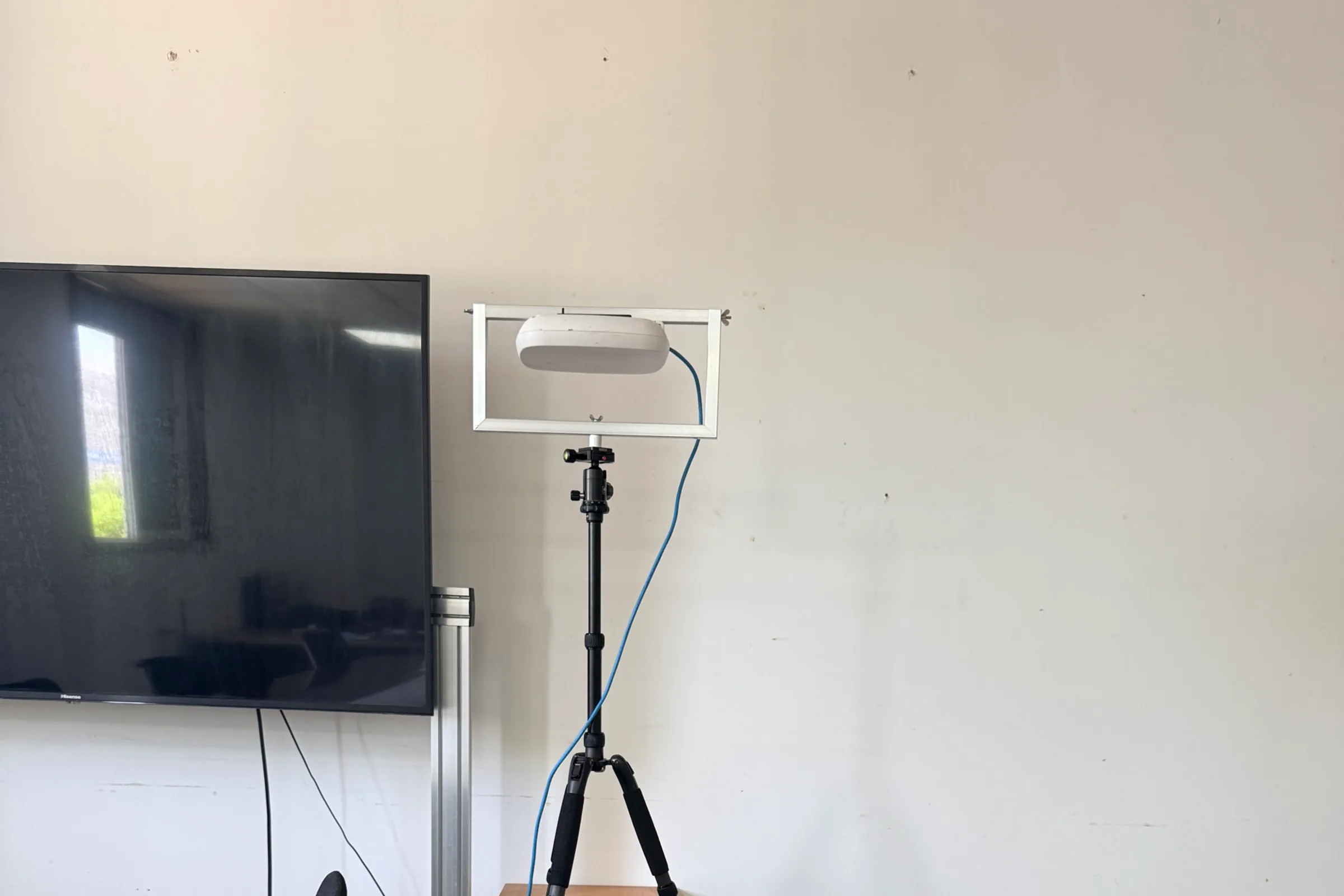 Access point secured in an adjustable frame on a tripod during an indoor APoS wireless survey